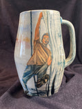 Ceramic mug with artistic depiction of a person on a dark fabric background